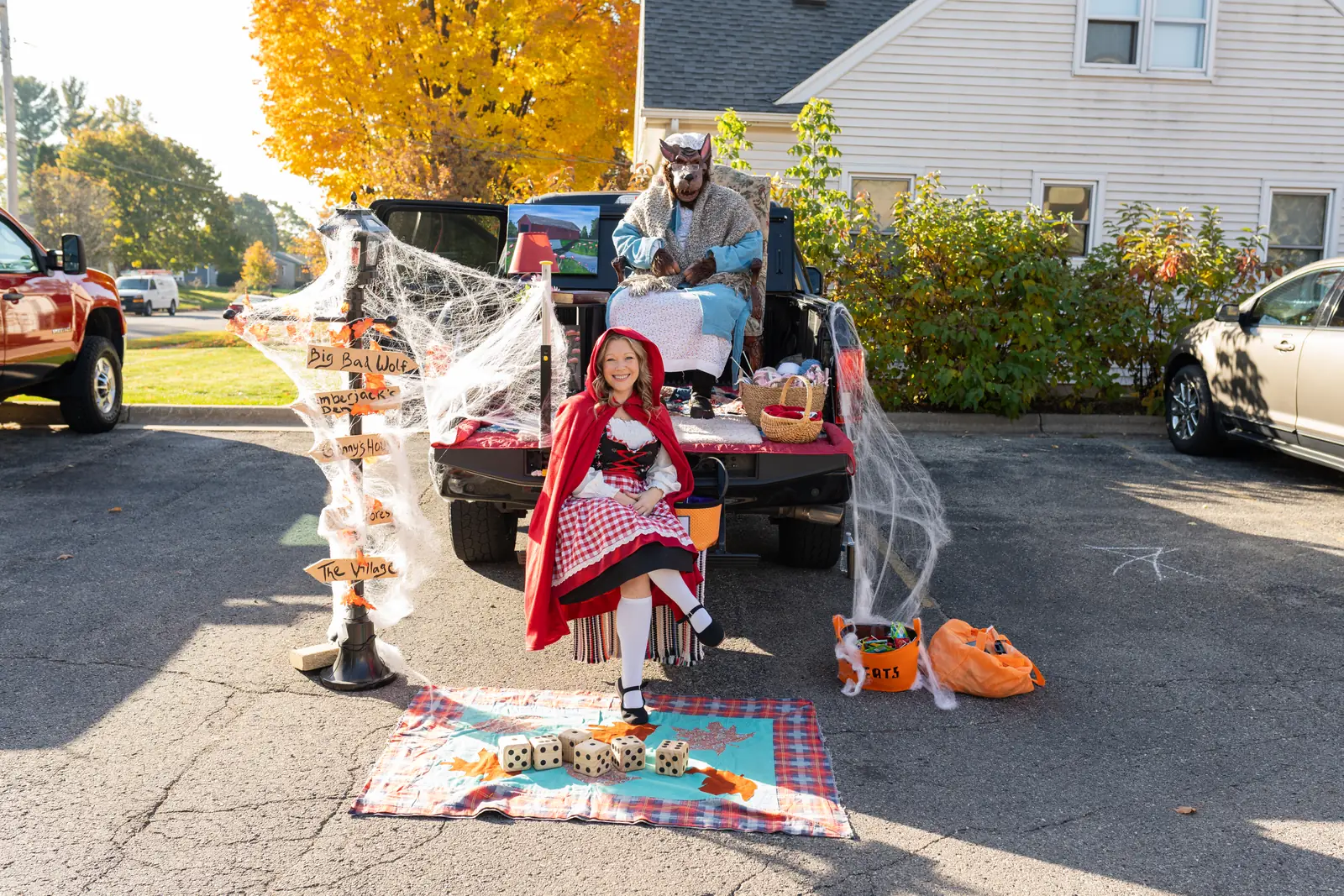 A volunteer dressed as Little Red Riding Hood at a decorated pickup truck trunk