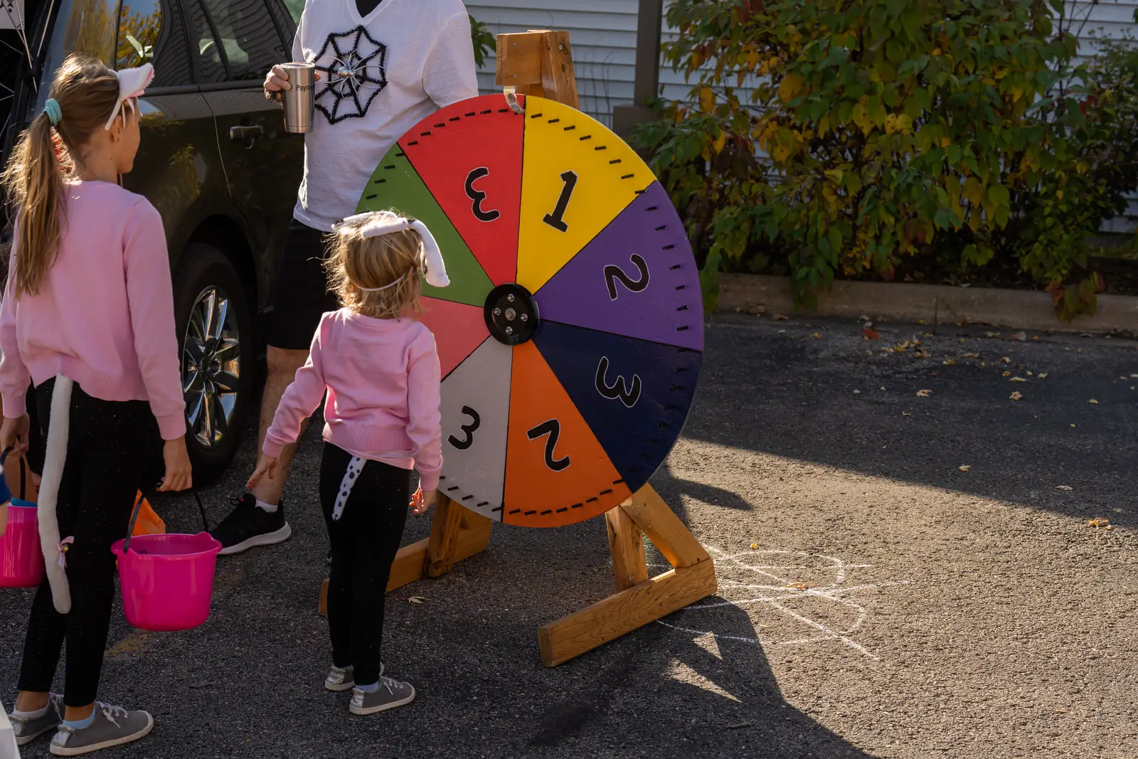 Kids playing a prize wheel game at a decorated trunk